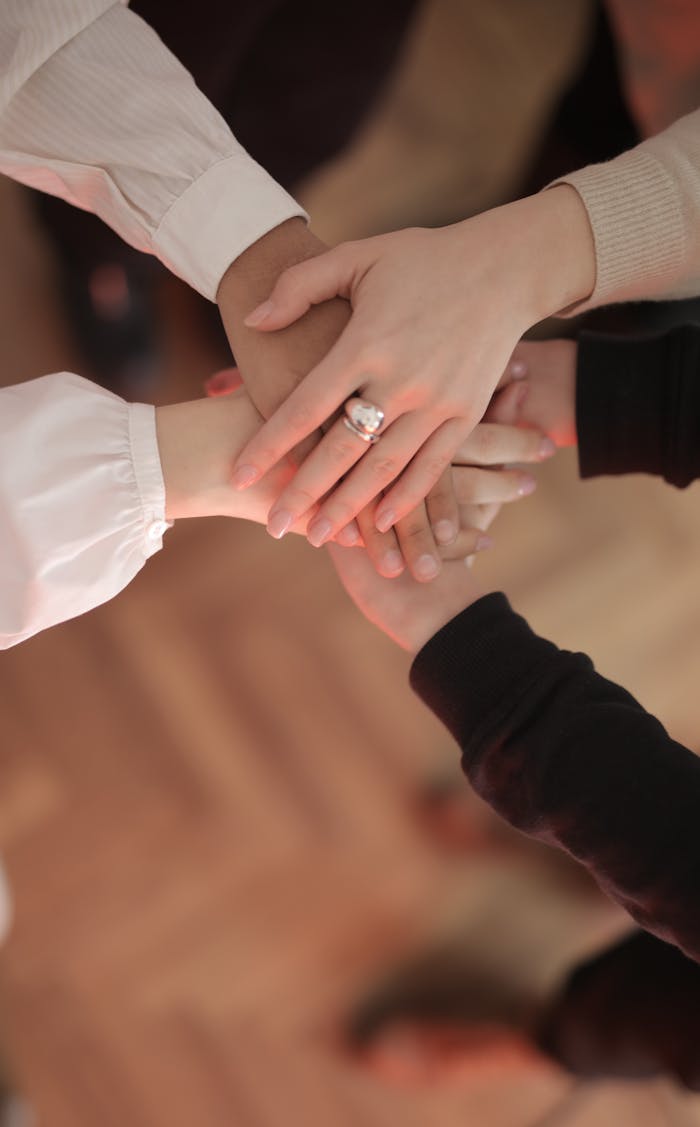 Crafting Captivating Headlines: Your awesome post title goes here Top view of faceless friends in different clothes stacking hands together while standing on wooden floor indoor on sunny day